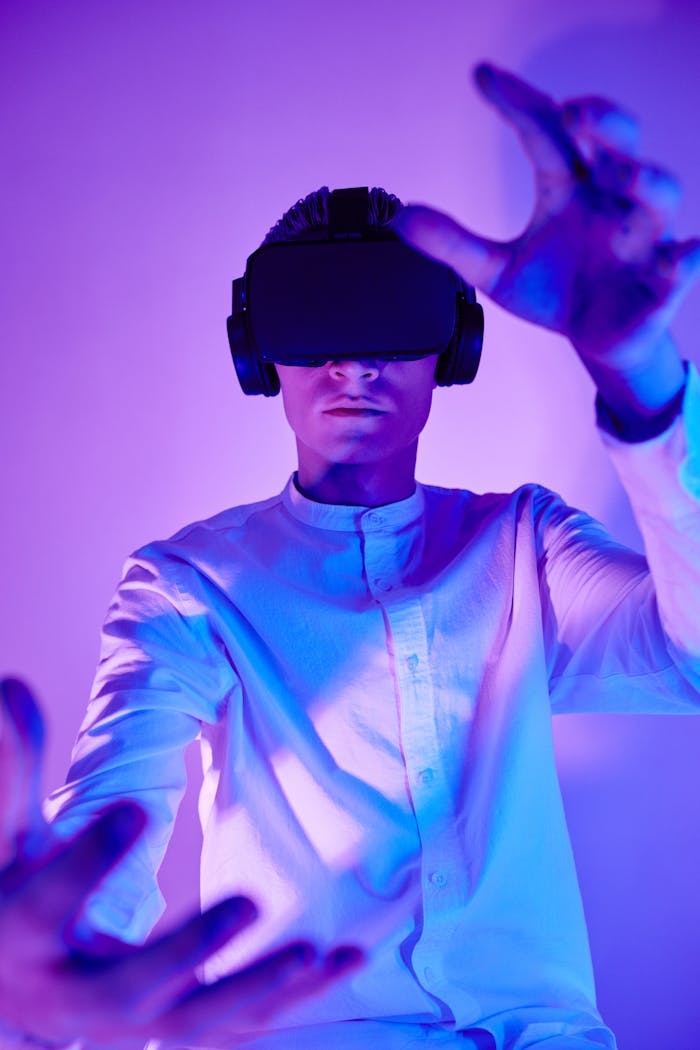 services-04 Person immersed in virtual reality using VR goggles in a vibrant studio setting.